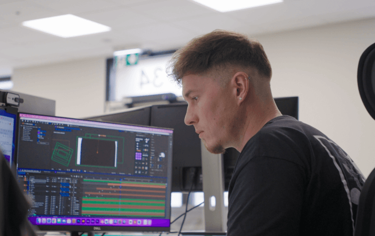 Man looking down at monitor with editing software on screen