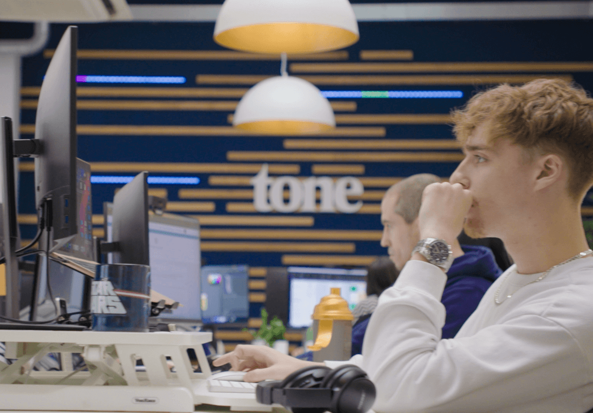 man sitting at desk using mouse on monitor