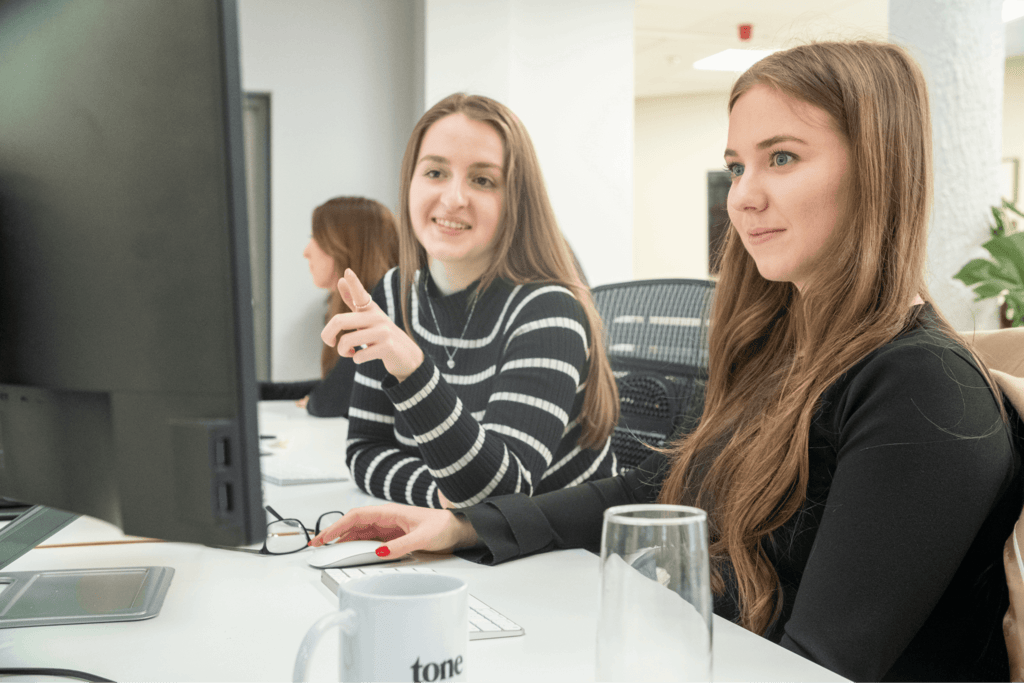 two women looking at monitor speaking