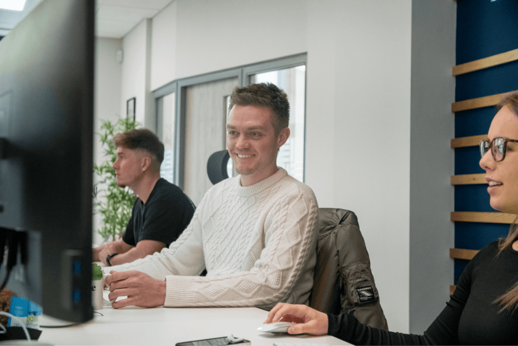 man smiling at monitor screen