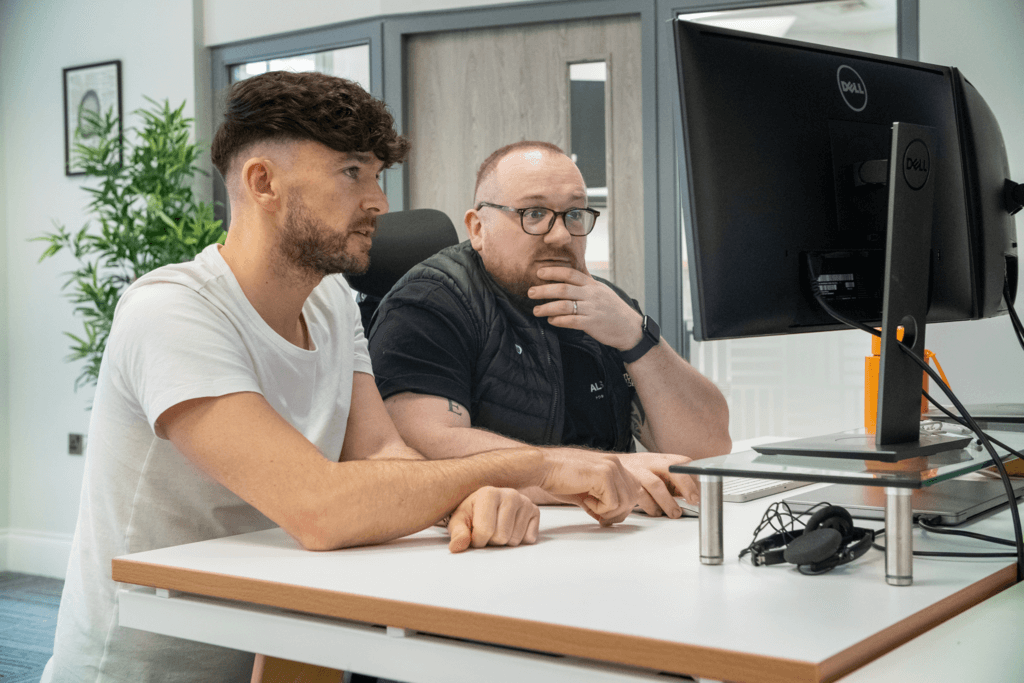 two men looking at monitor screen thinking